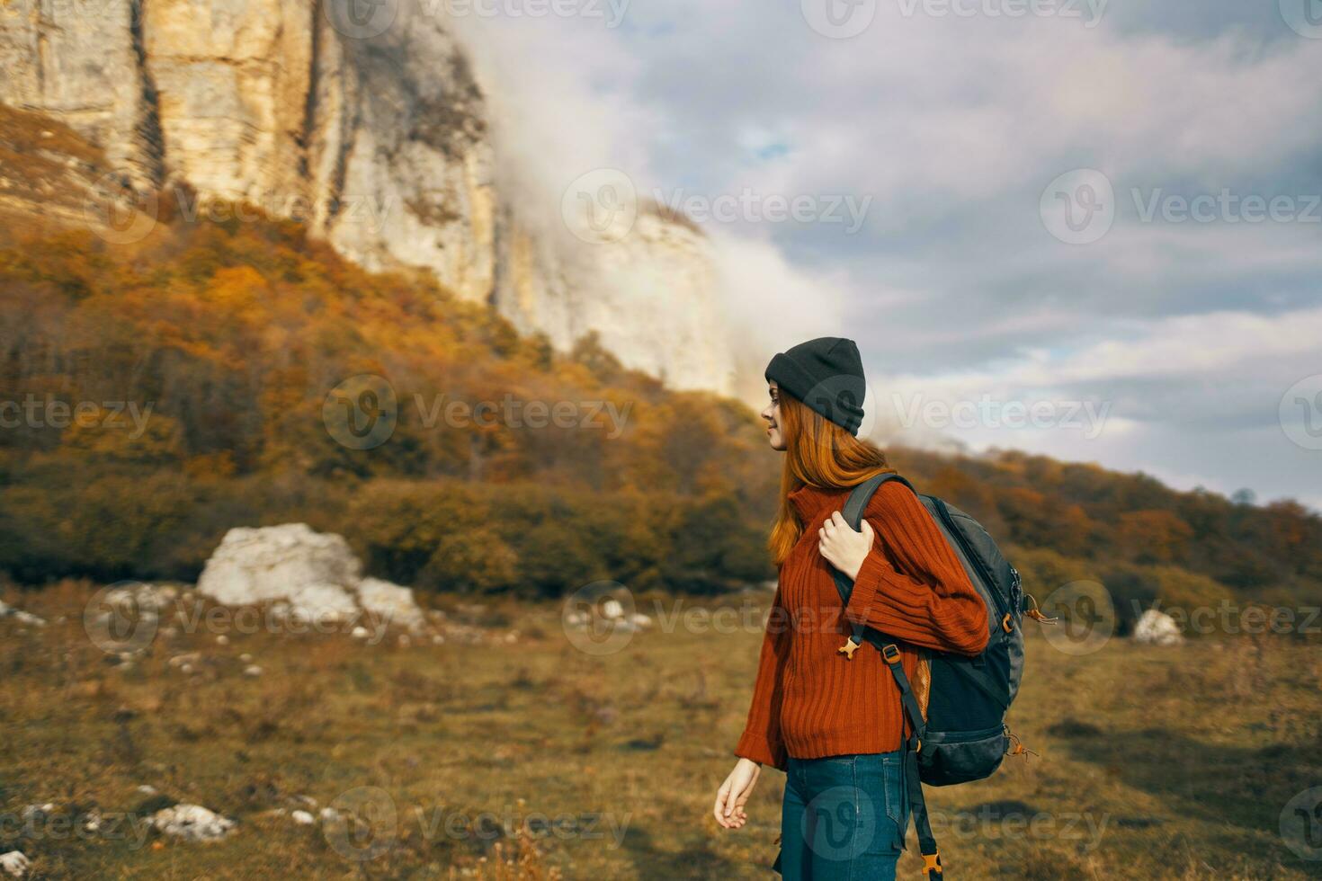 woman in a sweater with a backpack walks in the autumn in the mountains outdoors recreation model vacation photo