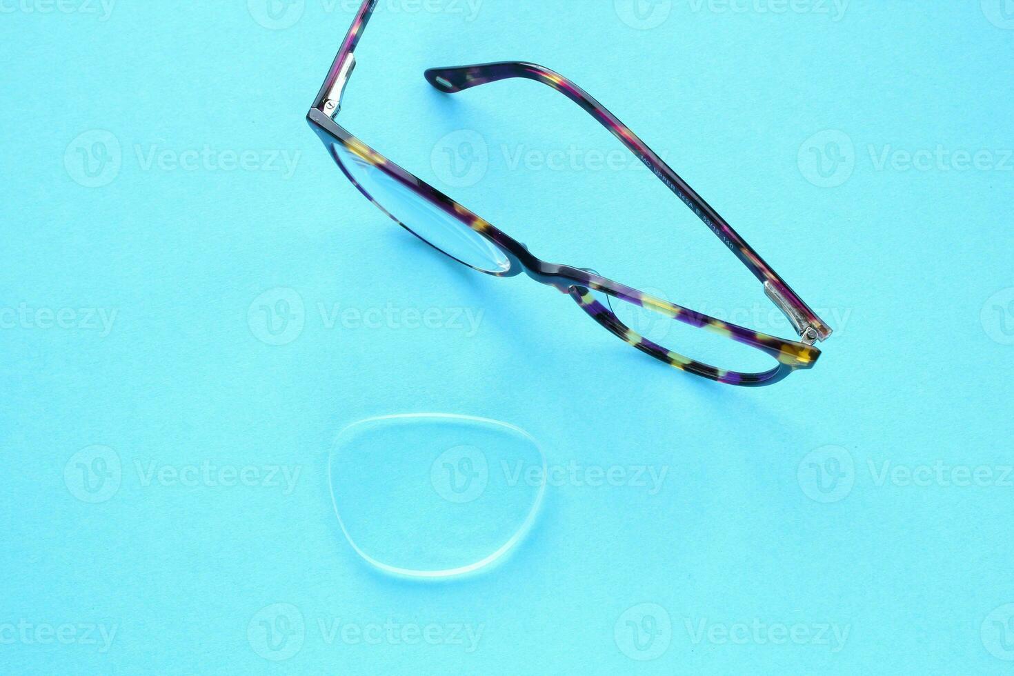 antiguo roto los anteojos con dañado lente en azul antecedentes. pobre vista. reutilizar y reparar concepto. idea de salud. fracaso óptico anteojos rotura de visión corrección lentes. cerca arriba, plano laico foto