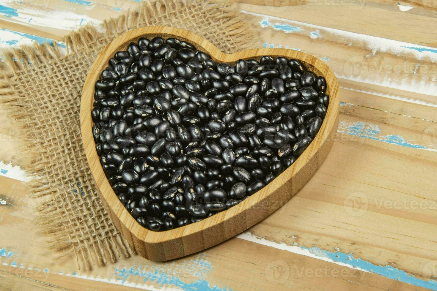 heart shaped black bean bowl on wooden table photo