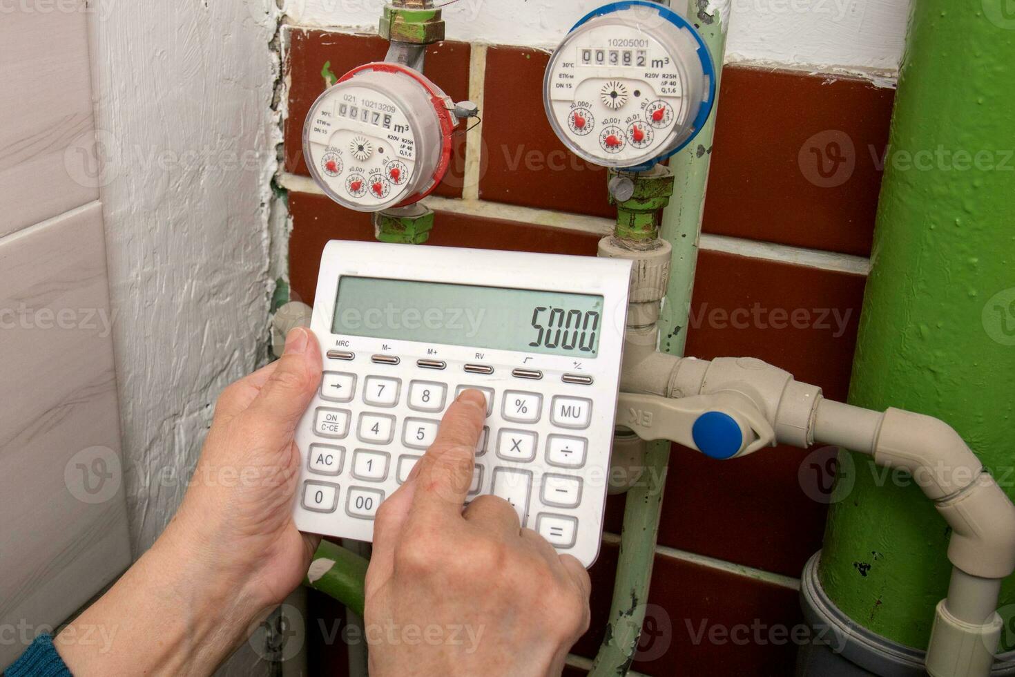 hands with a calculator at water meters, utility bills photo