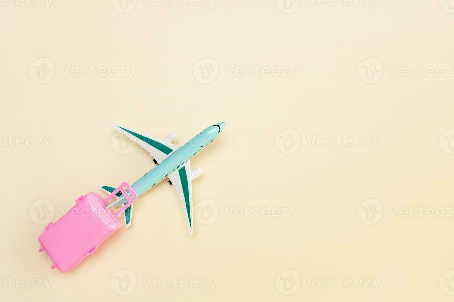 toy plane carries a suitcase on a light background with copy space, travel content photo