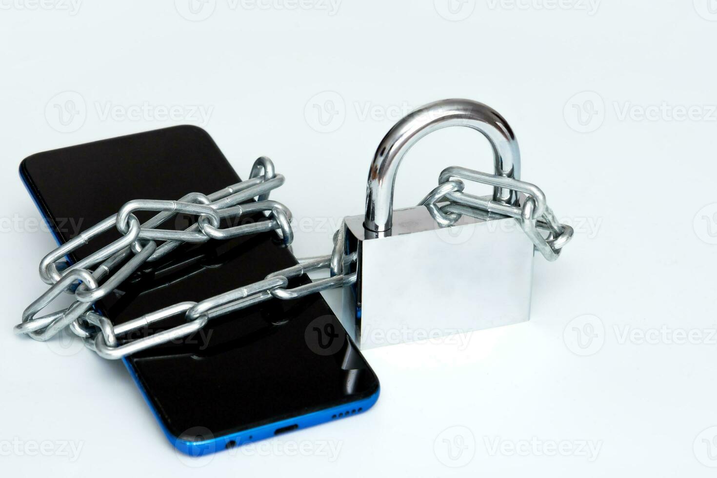 phone in chains and on a padlock on a white background photo