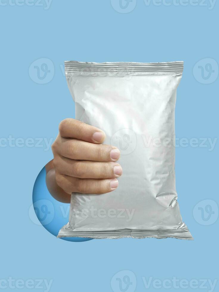 Foil food package mockup in hand on light blue background photo