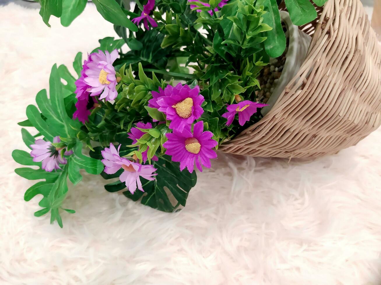 Close-up of artificial flowers on a light-colored carpet. photo