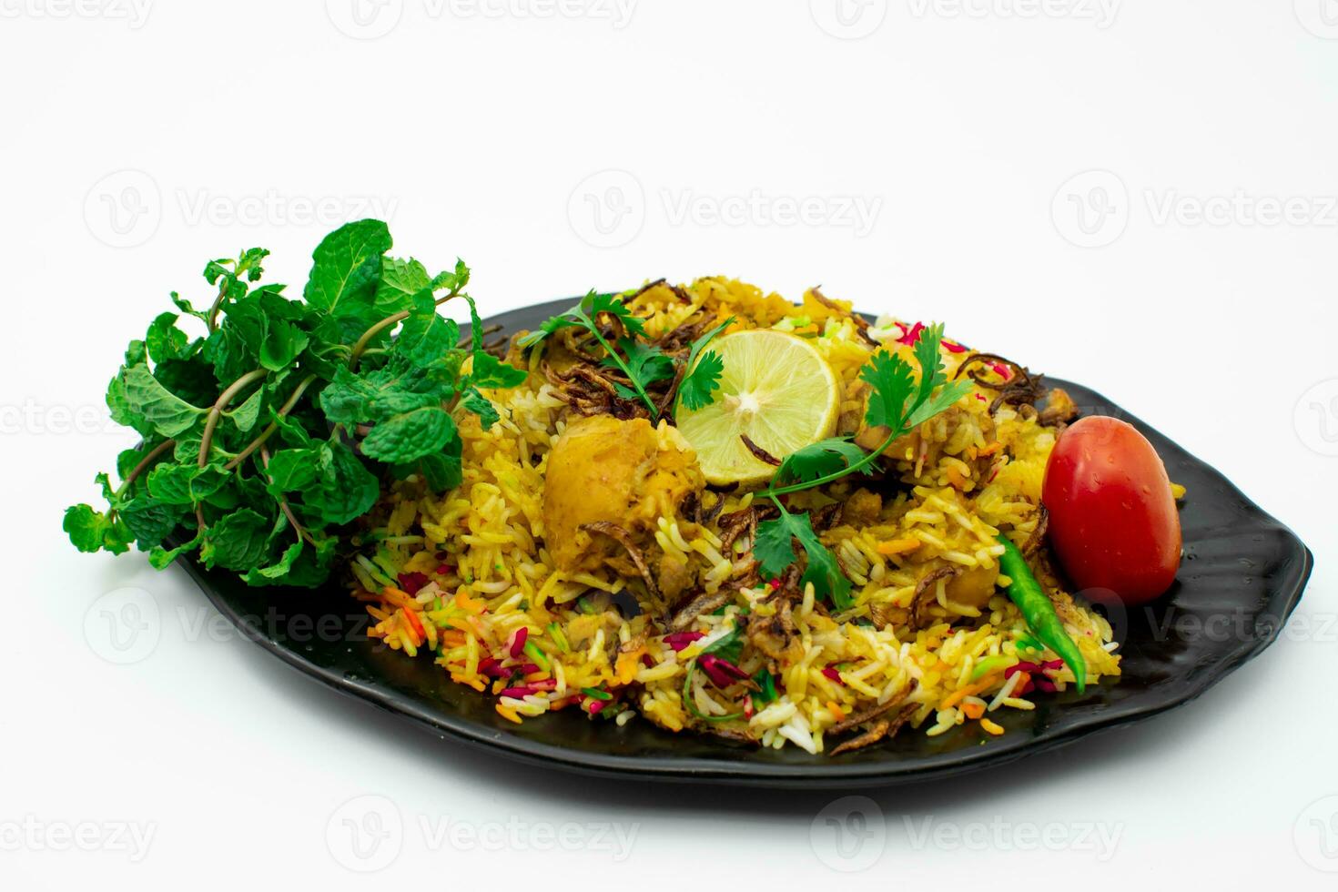 Isolated delicious spicy chicken biryani in black plate on white background photo