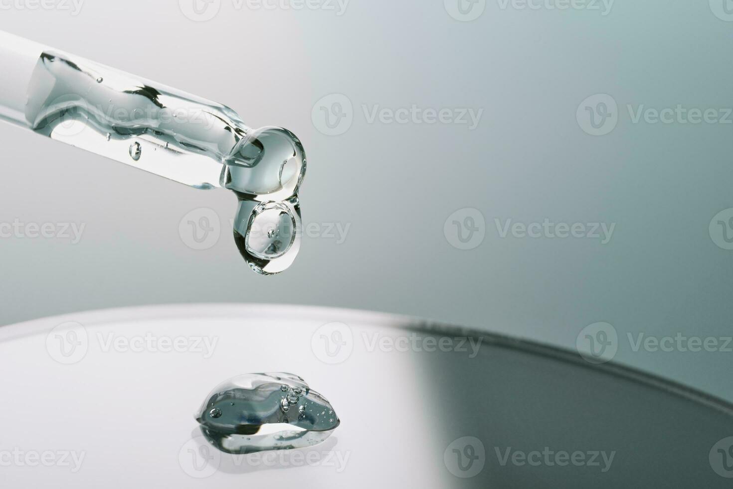 Pipette with sample of gels cosmetic product in petri dish on grey background, hard shadows, selective focus photo