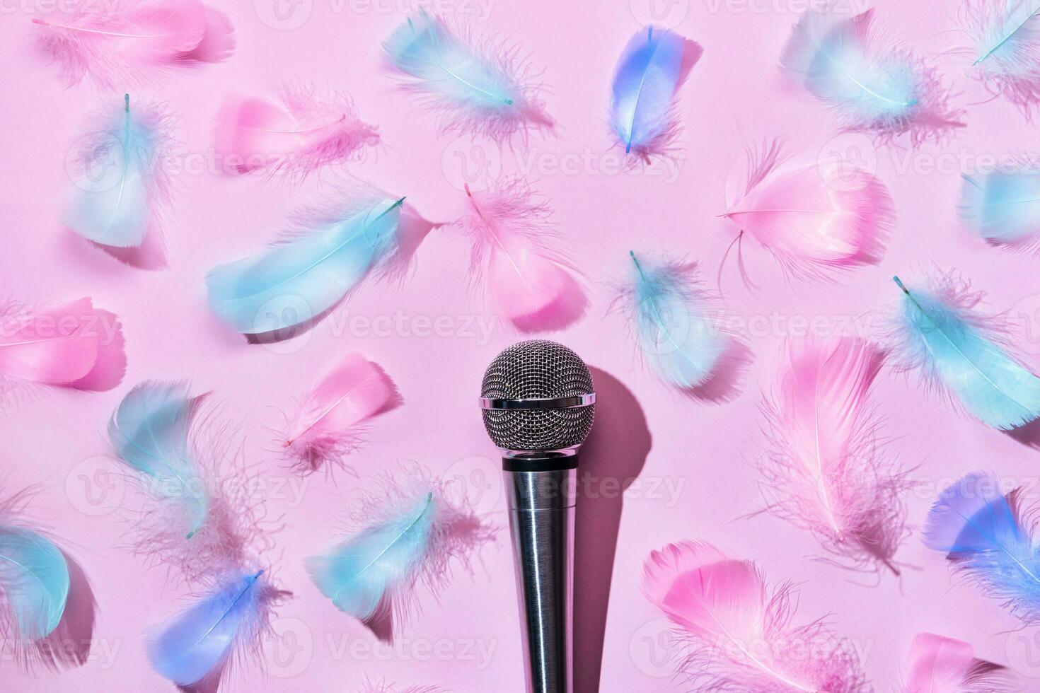 Microphone and soft feathers on pink background. ASMR recording stress relieving sounds concept, flat lay, trending shadows photo