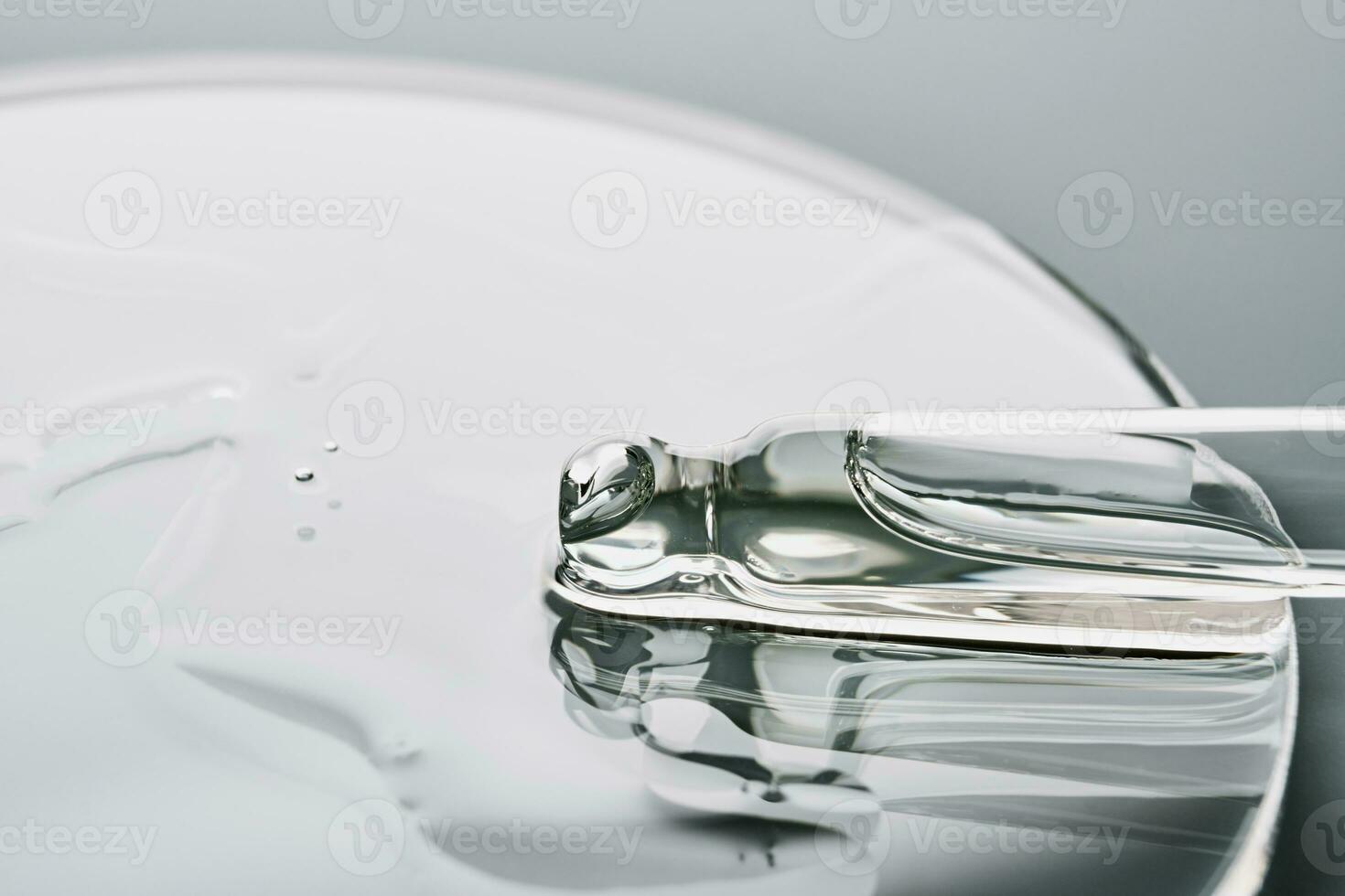 Pipette with sample of cosmetic product in petri dish on grey background, selective focus photo