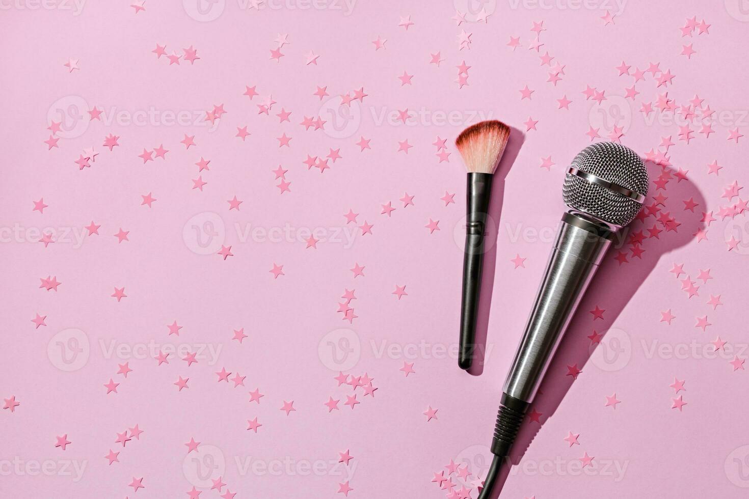 Microphone and brush on pink confetti background. ASMR recording stress relieving sounds concept, flat lay, trending shadows photo