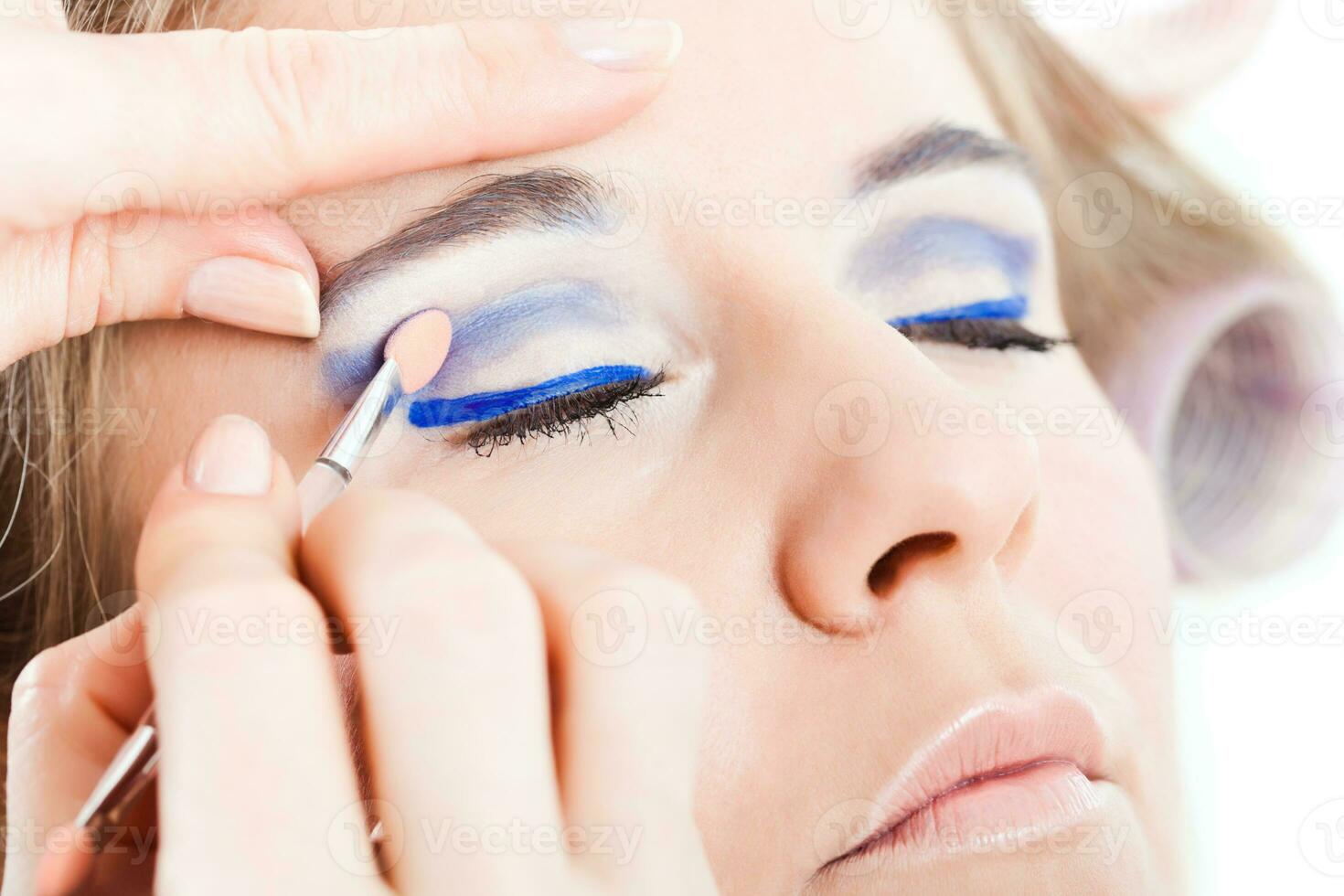 Woman getting her make-up done photo