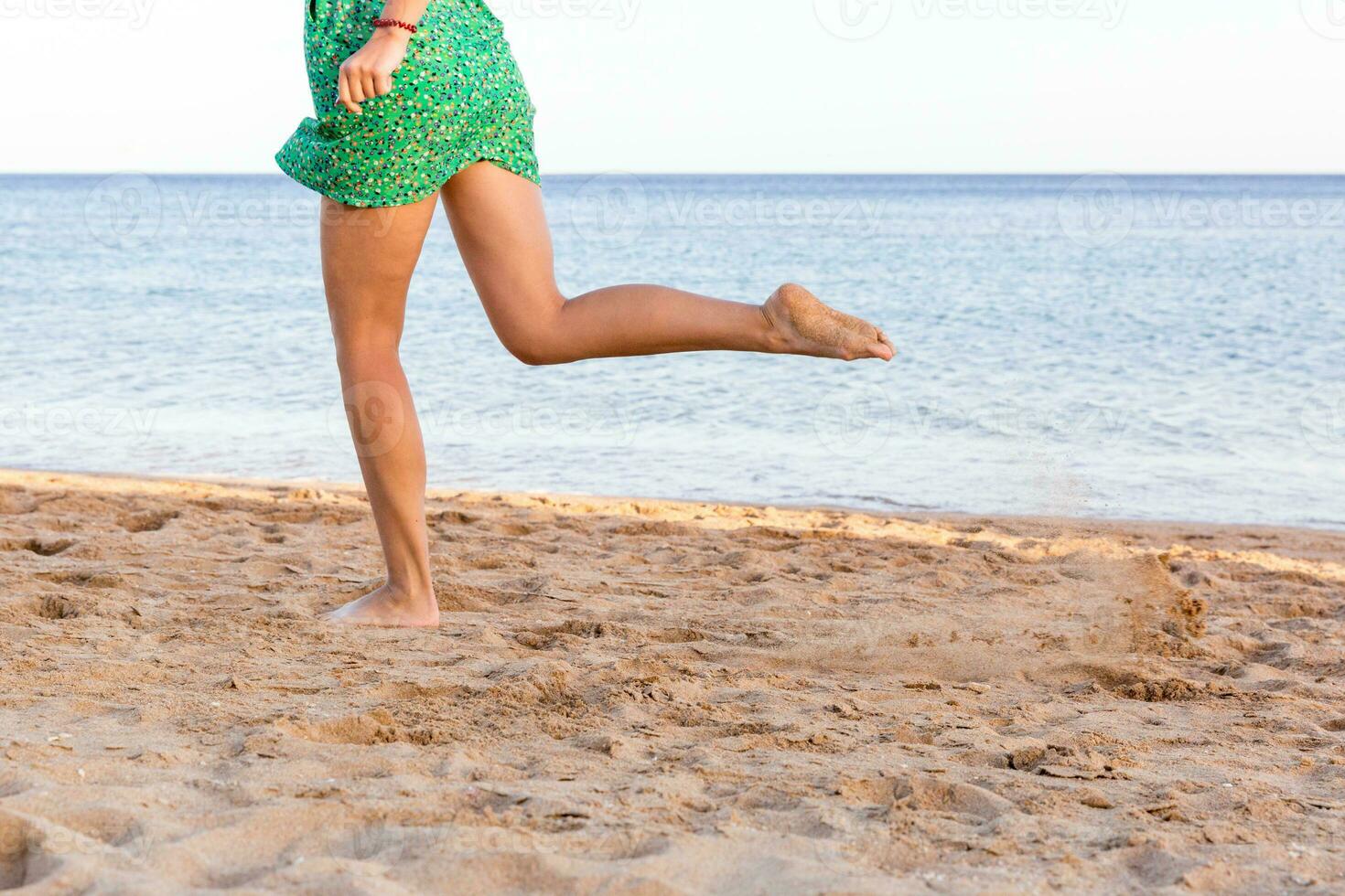 Leg of woman running on sand beach. summer vacation. Happy beautiful woman running on the beach photo
