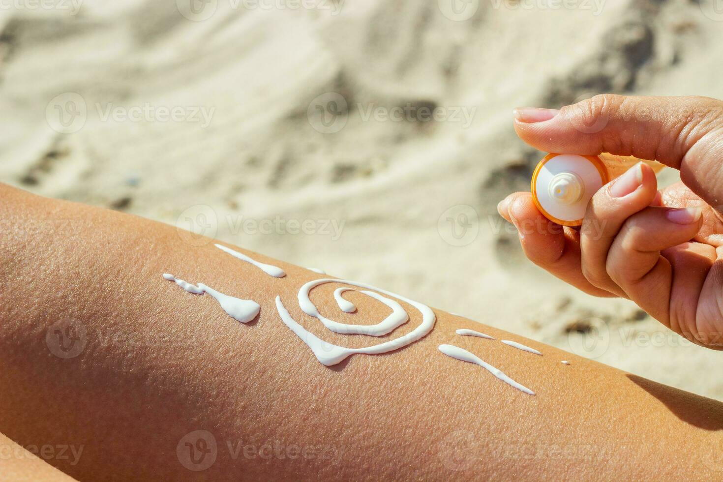 A girl smears her leg with sunscreen. Legs protected from strong sun photo