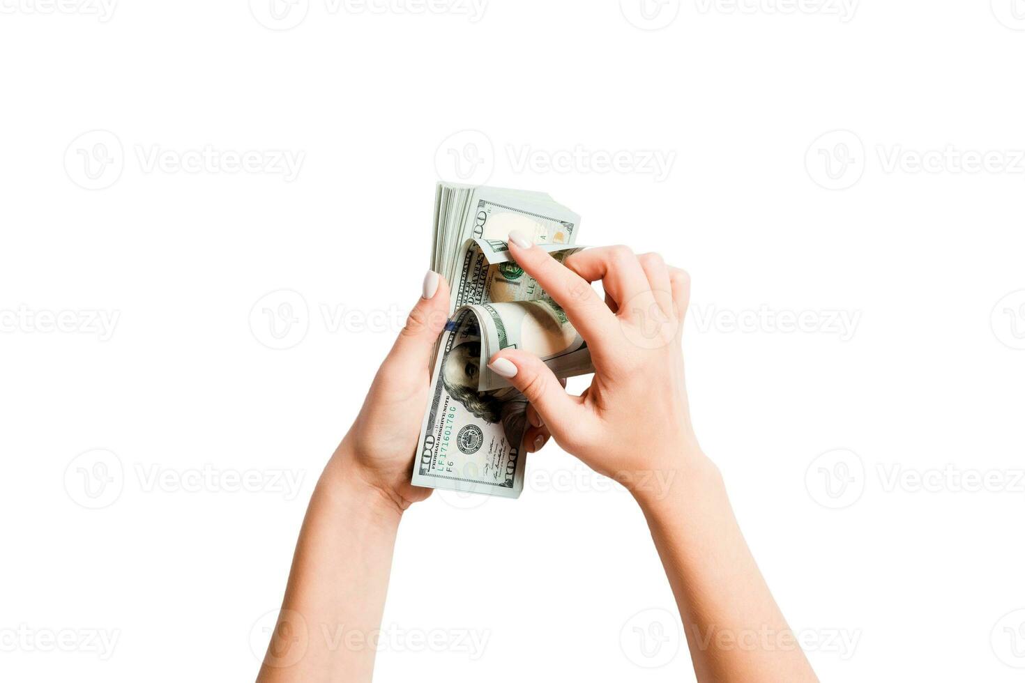 Top view of a bundle of money in female hands. Image of counting dollars on white isolated background. Tax concept photo