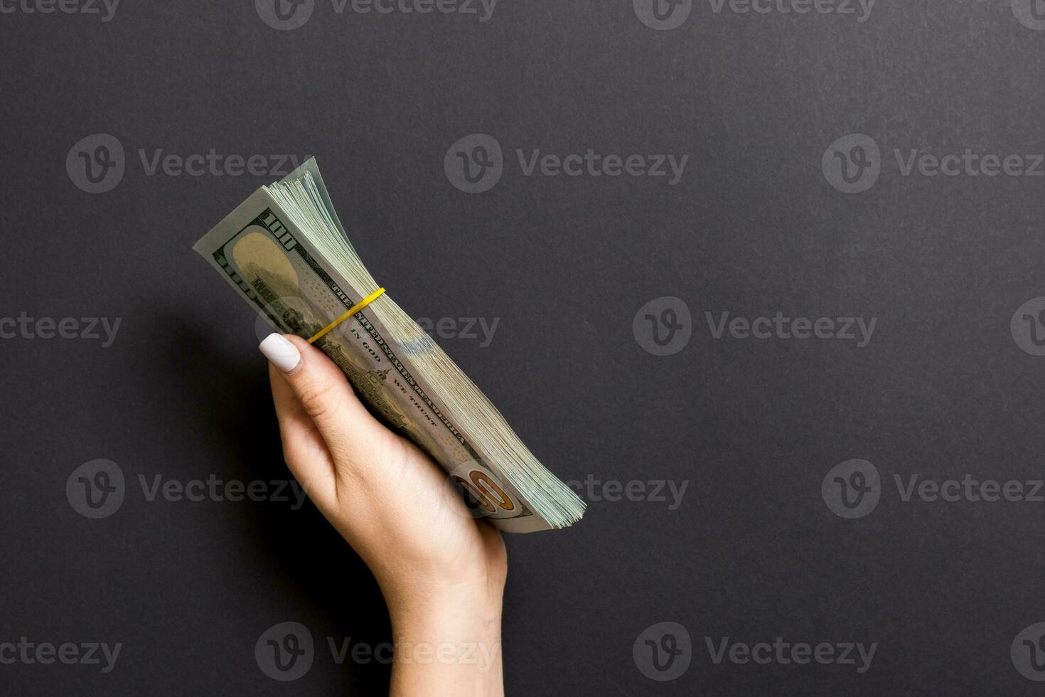 Bundle of one hundred dollar banknotes in female hand on colorful background. Financial and business concept with copy space photo