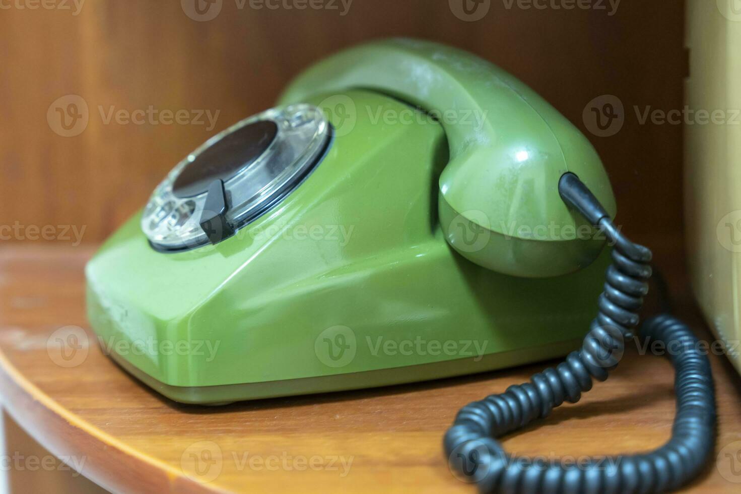 green vintage phone with a rotating dial dial. the phone on the shelf photo