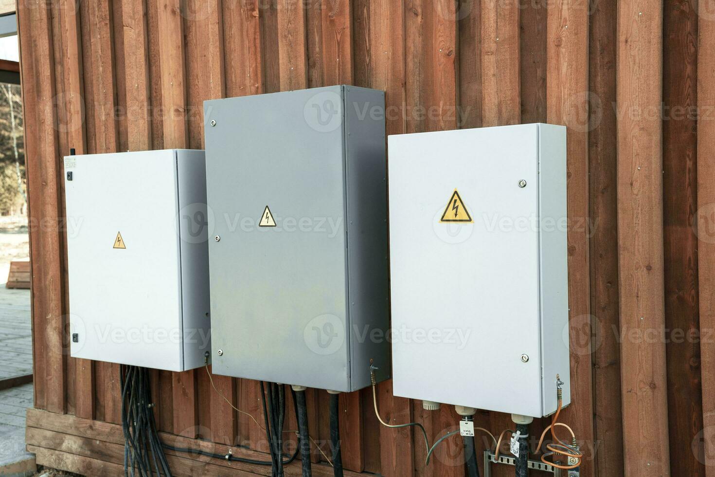 electrical panels and electrical cables connected to them on the wall photo