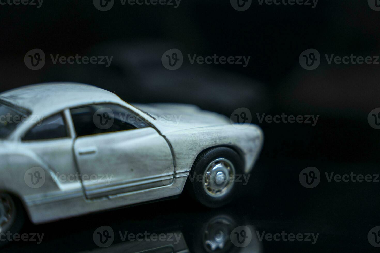 a model of an old classic shabby car on a glossy black glass background photo