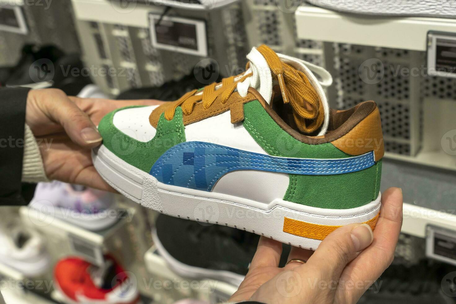 women's hands hold a new sneaker taken from the shelf of sports store photo