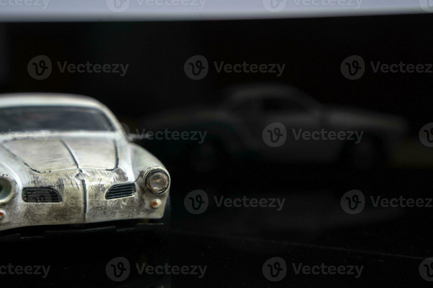 a model of an old classic shabby car on glossy black glass. close-up photo