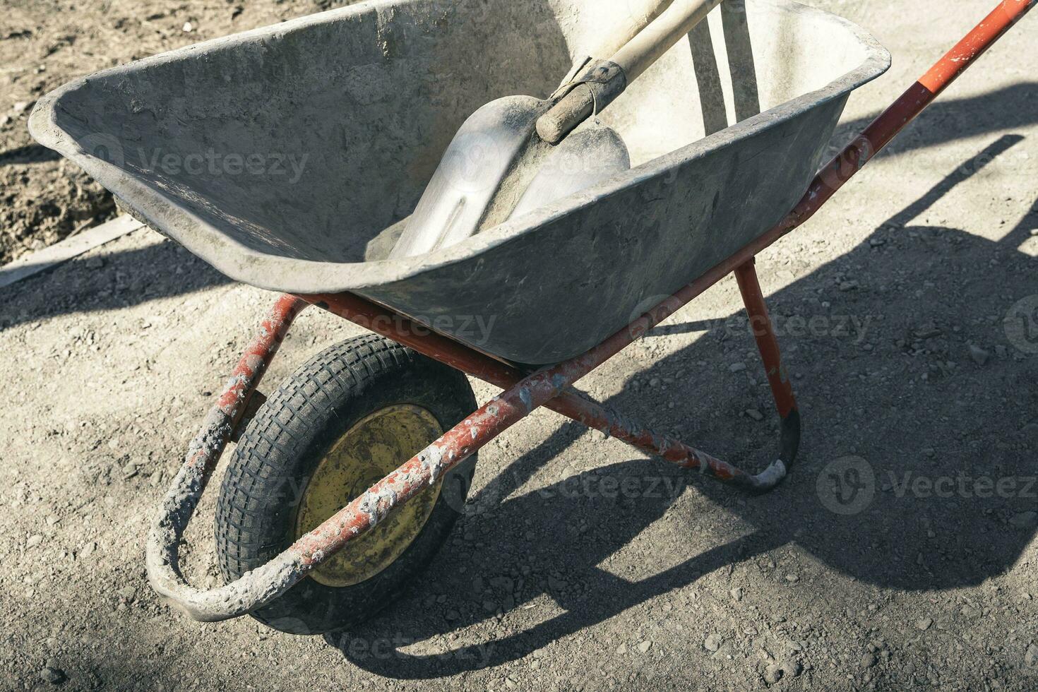 old reliable working wheelbarrow with shovels on a construction site photo