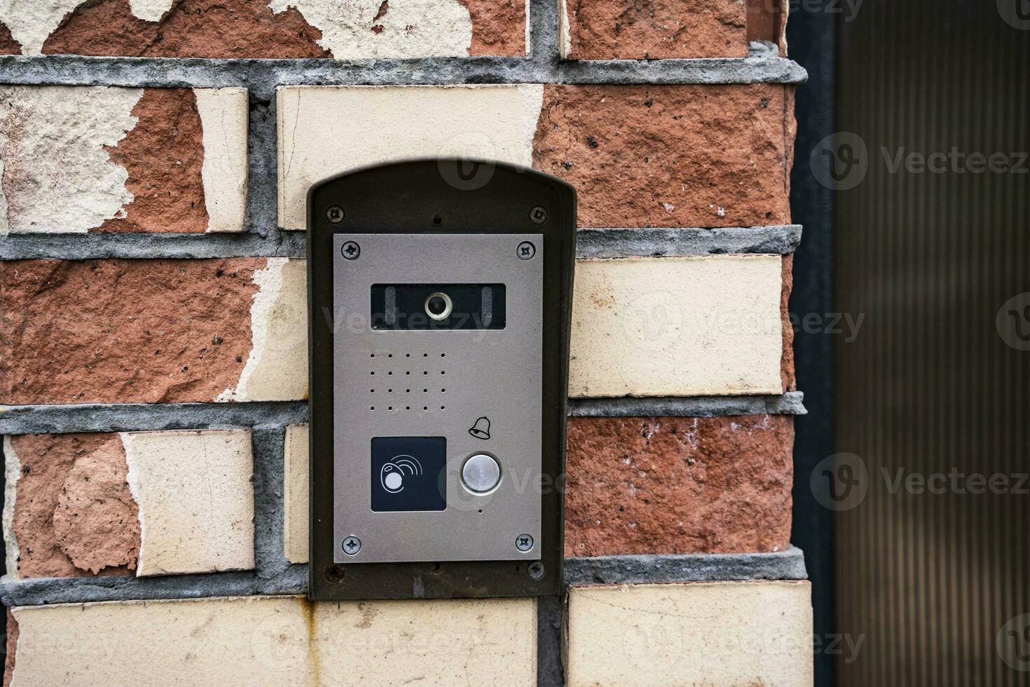 intercom panel with a video camera on the brick fence of private house photo