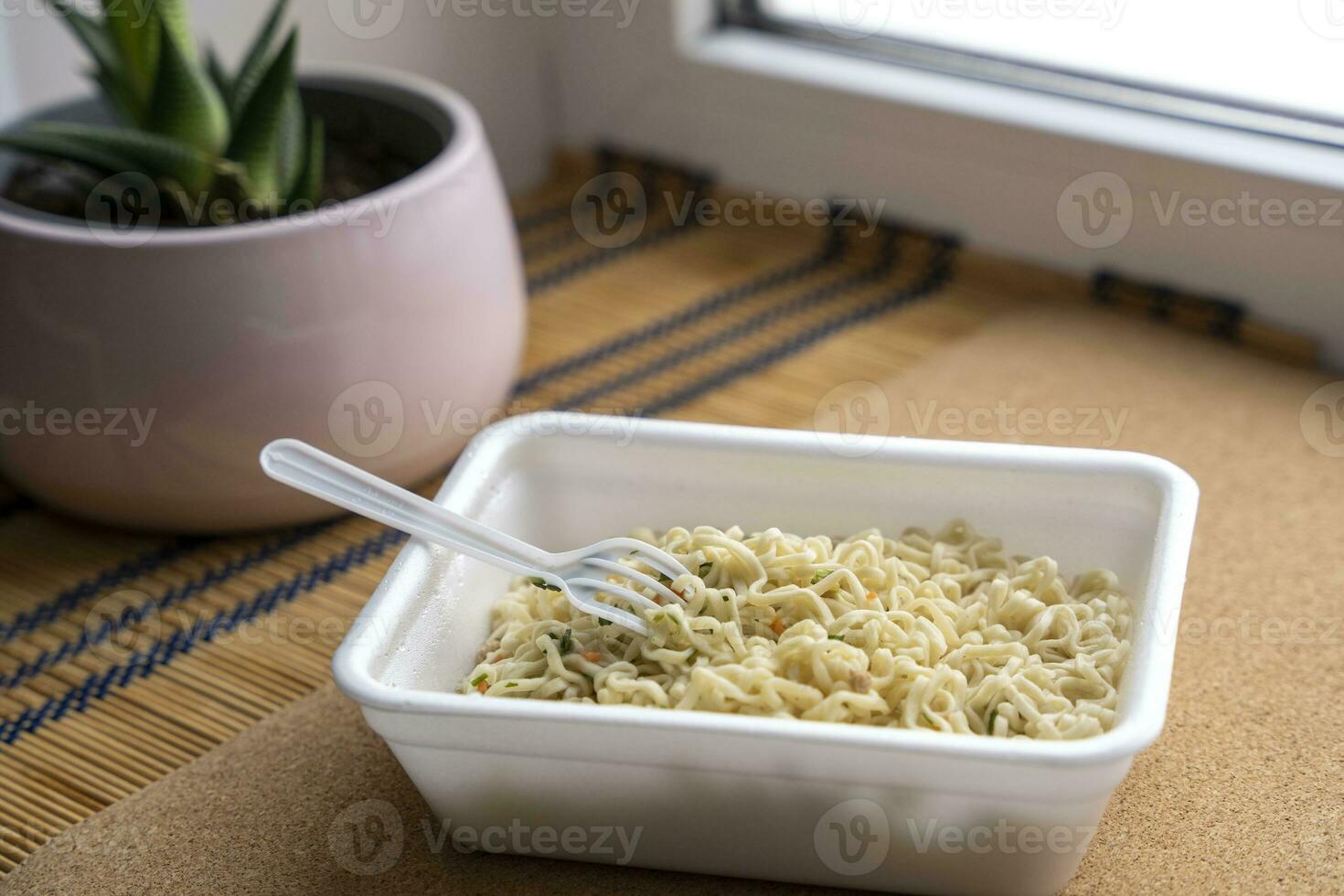 Chinese noodles close-up on the windowsill doshirak noodles in a plastic box. Instant noodles photo