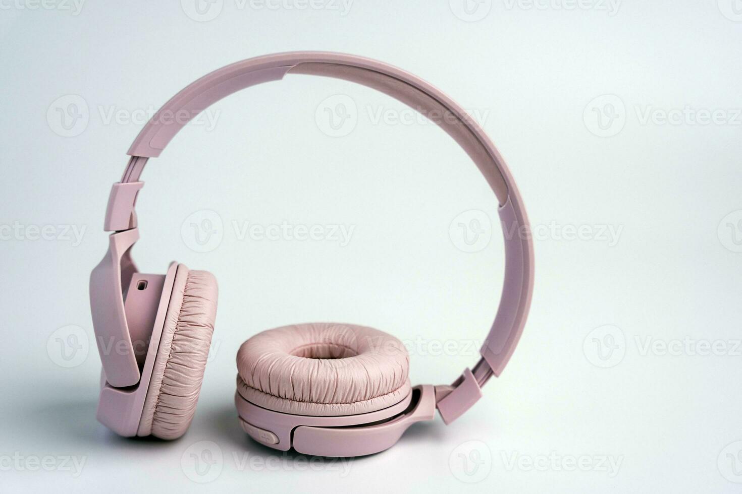 pink wireless headphones on a white background. Music time. space for text photo