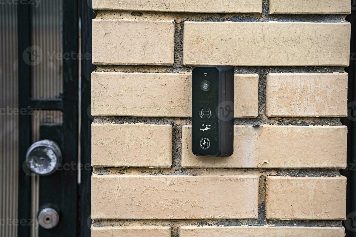 intercom panel with a video camera on the brick fence of private house photo