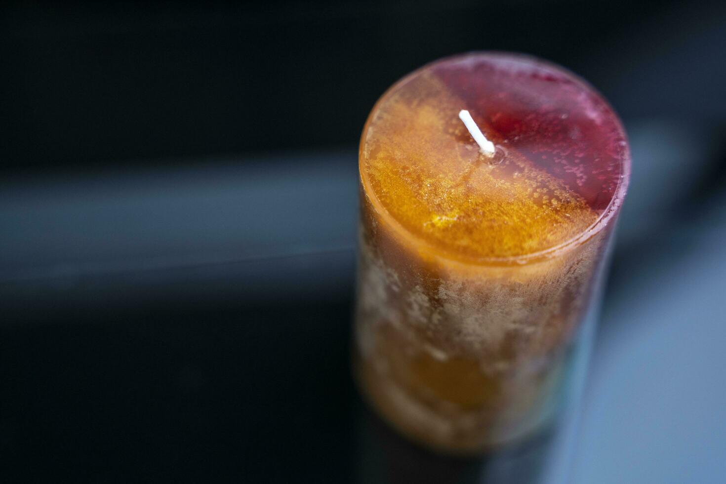 aromatic colored decorative candle on a dark background, aromatherapy photo