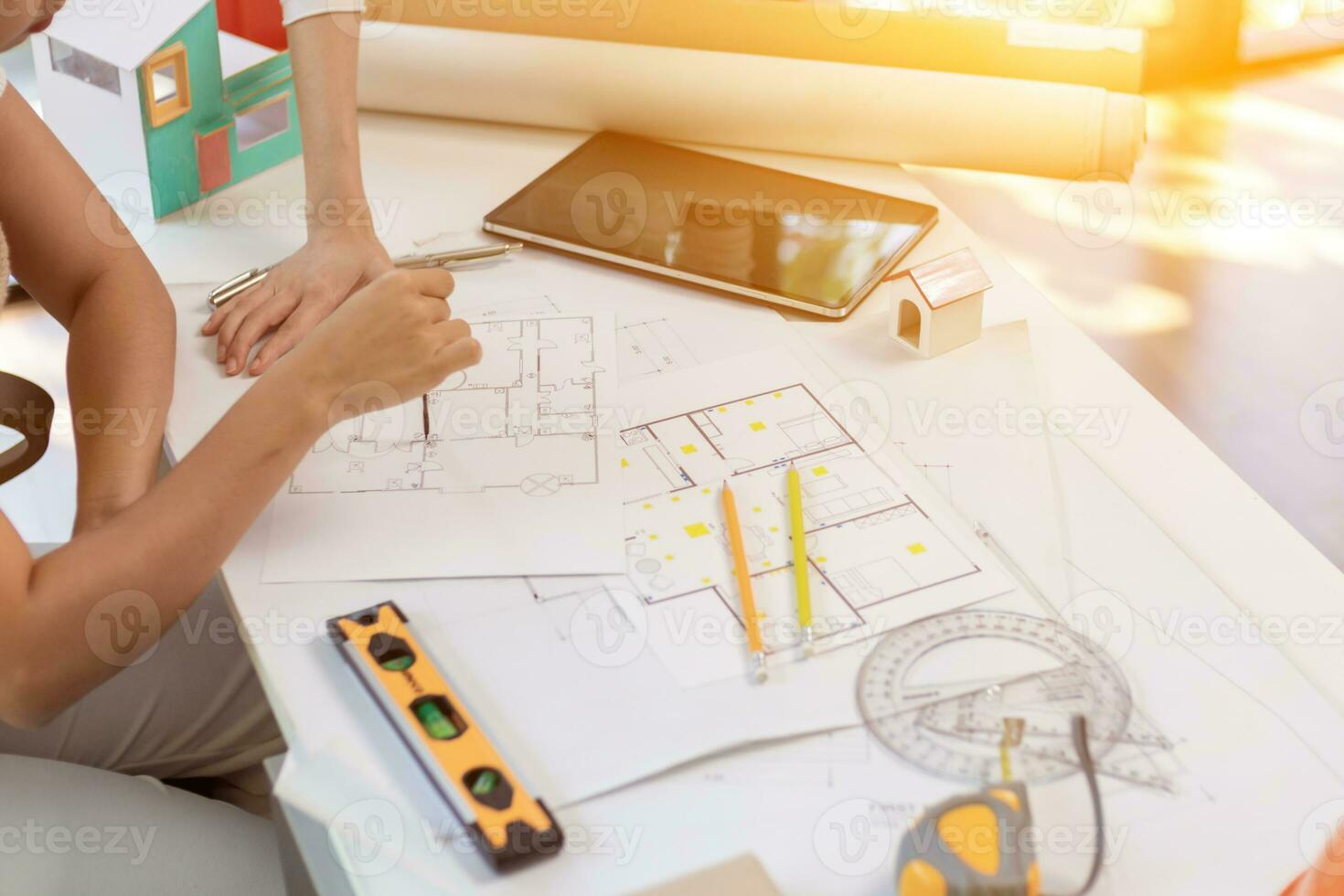 Engineers and designers are discussing the layout of the house and the construction schedule to be completed on schedule. House construction ideas with a team of professional engineers and designers. photo