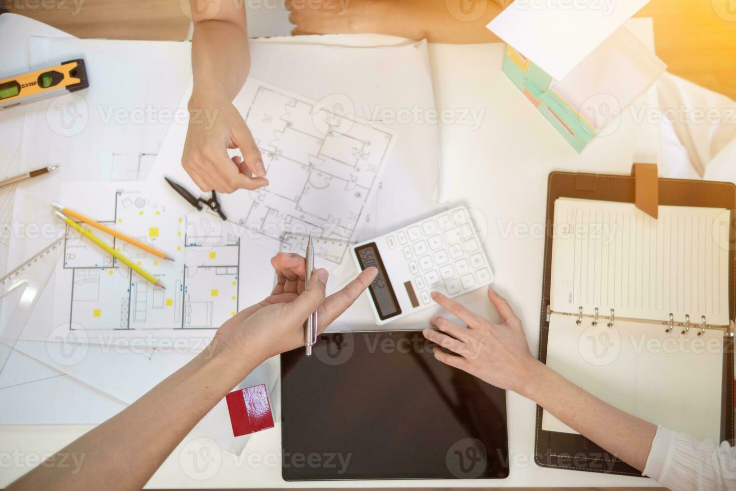 Engineers and designers are discussing the layout of the house and the construction schedule to be completed on schedule. House construction ideas with a team of professional engineers and designers. photo