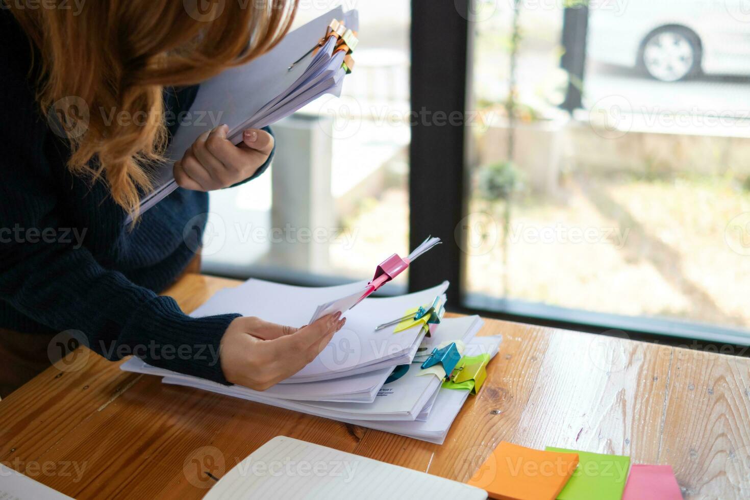 mujer de negocios manos trabajando en pilas de papel documentos a buscar y revisión documentos apilado en mesa antes de enviando ellos a tablero de directores a utilizar correcto documentos en reunión con empresario foto