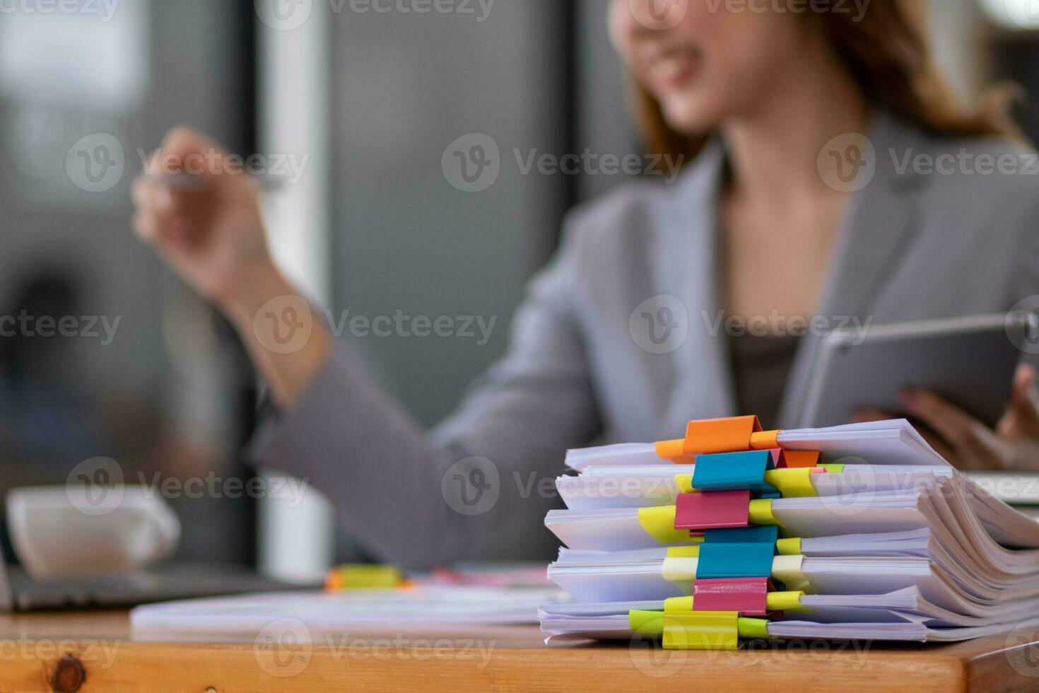 mujer de negocios manos trabajando en pilas de papel documentos a buscar y revisión documentos apilado en mesa antes de enviando ellos a tablero de directores a utilizar correcto documentos en reunión con empresario foto