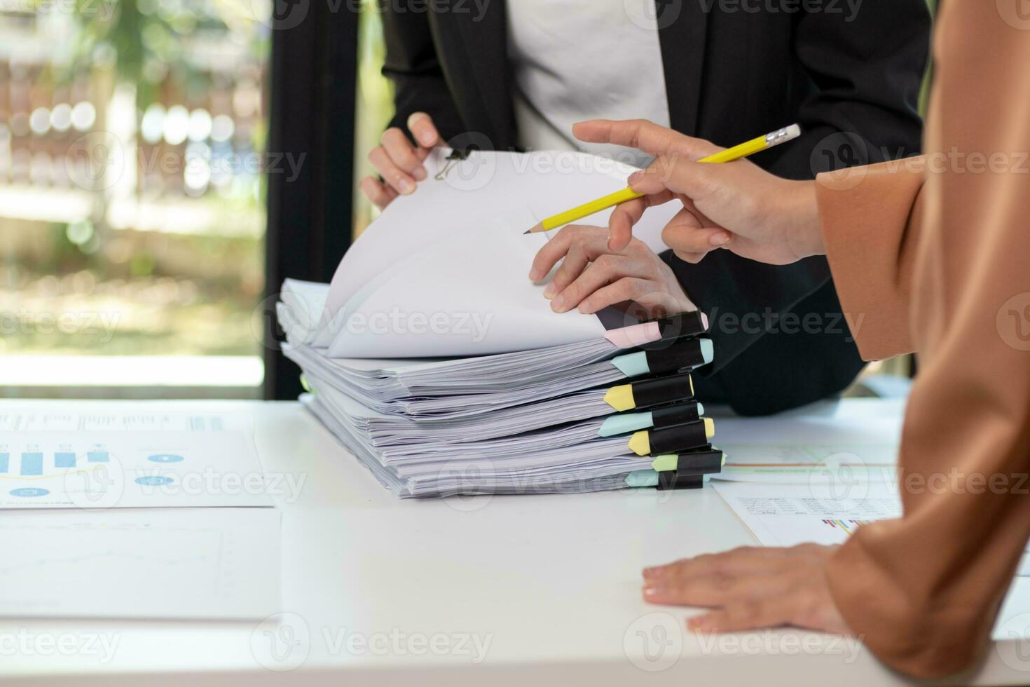 mujer de negocios manos trabajando en pilas de papel documentos a buscar y revisión documentos apilado en mesa antes de enviando ellos a tablero de directores a utilizar correcto documentos en reunión con empresario foto