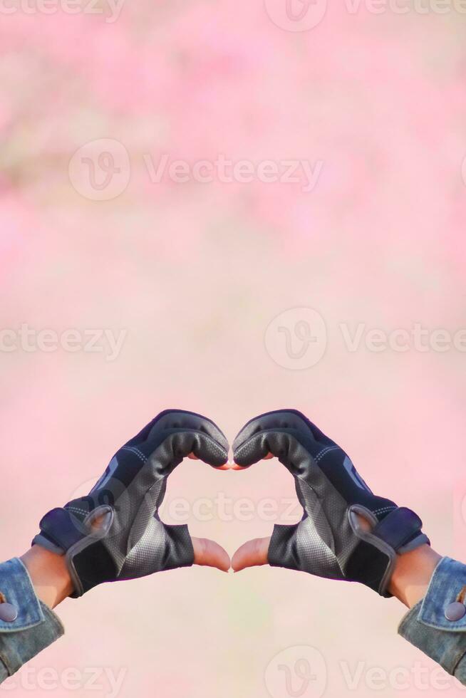 man holds her hand above her head to form heart symbol that represents love, friendship and kindness between lovers and friends. heart symbol is concept that represents friendship, love and kindness. photo