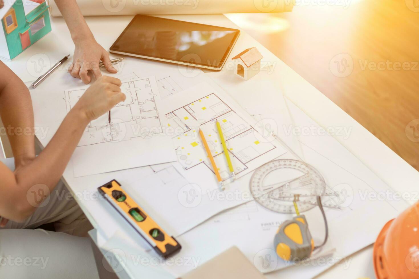 Engineers and designers are discussing the layout of the house and the construction schedule to be completed on schedule. House construction ideas with a team of professional engineers and designers. photo