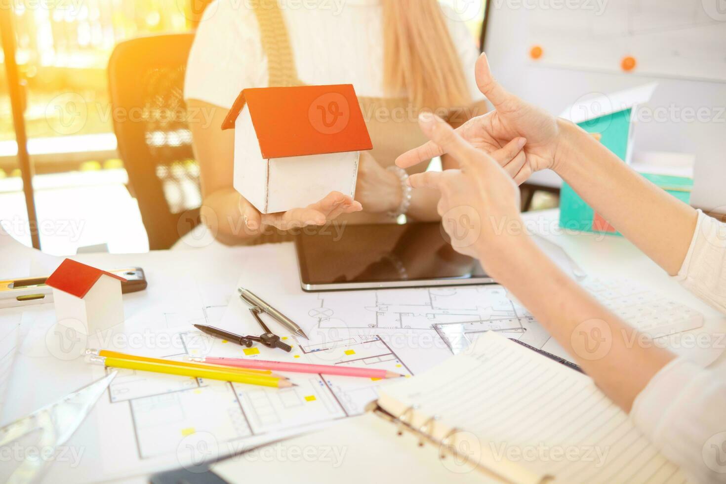Engineers and designers are discussing the layout of the house and the construction schedule to be completed on schedule. House construction ideas with a team of professional engineers and designers. photo