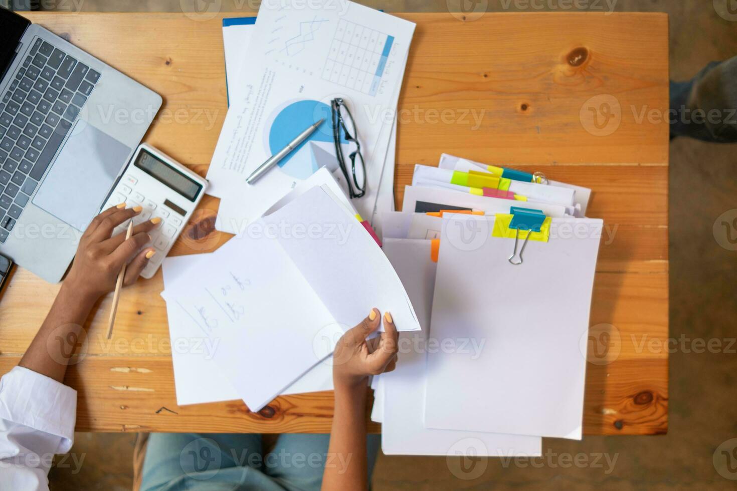 Businesswoman hands working on stacks of paper documents to search and review documents piled on table before sending them to board of directors to use  correct documents in meeting with Businessman photo