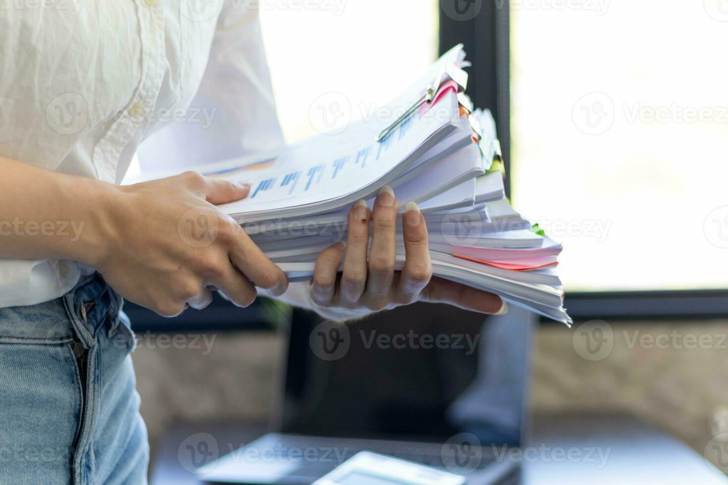 Businesswoman hands working on stacks of paper documents to search and review documents piled on table before sending them to board of directors to use  correct documents in meeting with Businessman photo