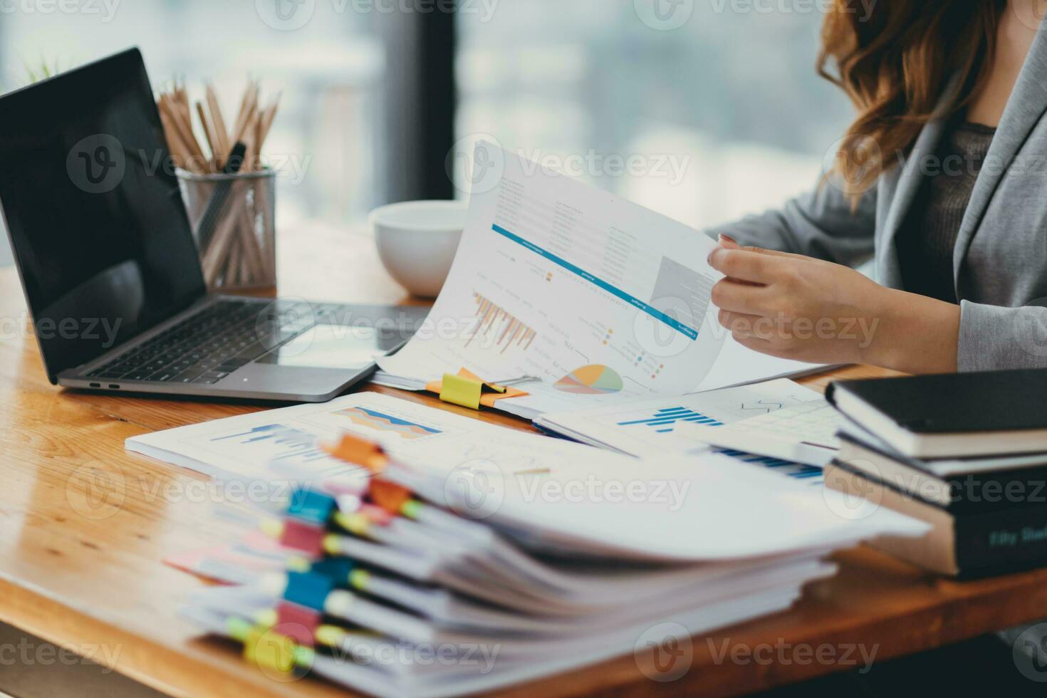 Businesswoman hands working on stacks of paper documents to search and review documents piled on table before sending them to board of directors to use  correct documents in meeting with Businessman photo