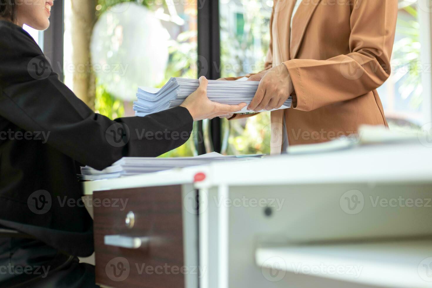 mujer de negocios manos trabajando en pilas de papel documentos a buscar y revisión documentos apilado en mesa antes de enviando ellos a tablero de directores a utilizar correcto documentos en reunión con empresario foto