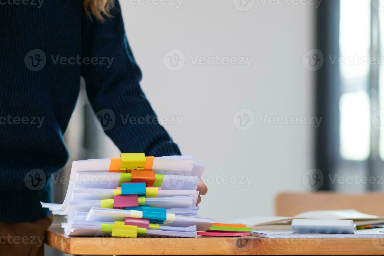 Businesswoman hands working on stacks of paper documents to search and review documents piled on table before sending them to board of directors to use  correct documents in meeting with Businessman photo