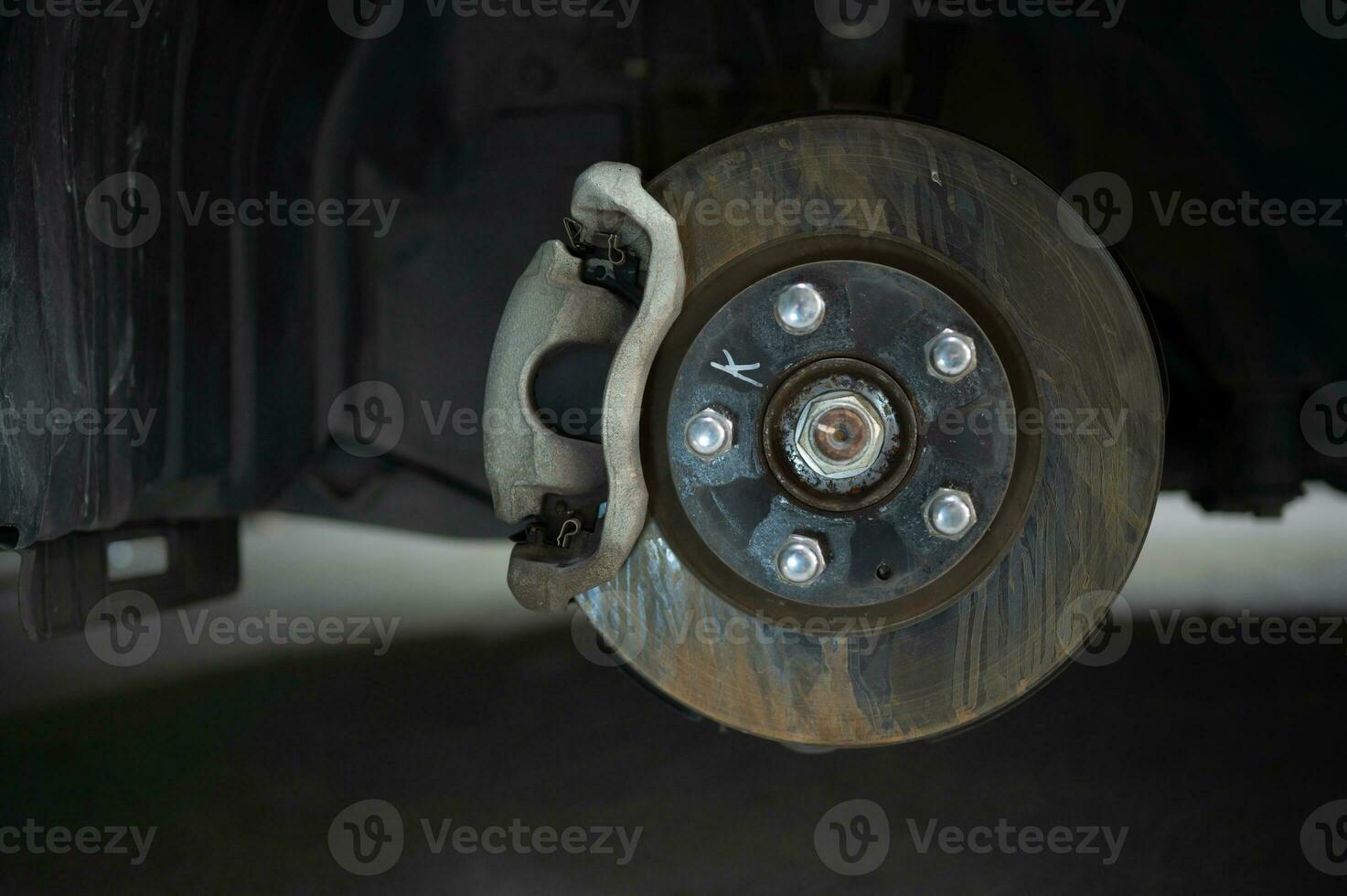 A auto mechanic checking the condition of a car's brake discs that have been used for a while photo