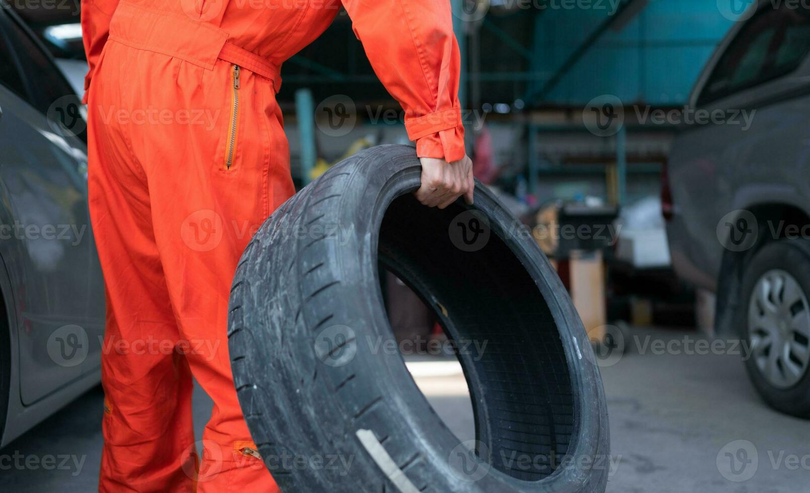 A car mechanic inspects the condition of a car tire before placing it on a vehicle. photo