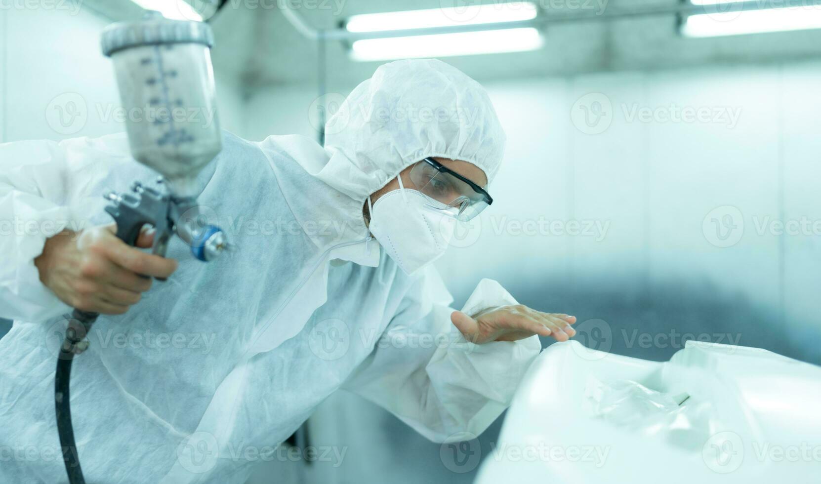 Auto mechanic in car spray room Inspecting the paint sprayed into the front bumper of the car that the pigment is complete, beautiful, harmonious with the original color of the car photo