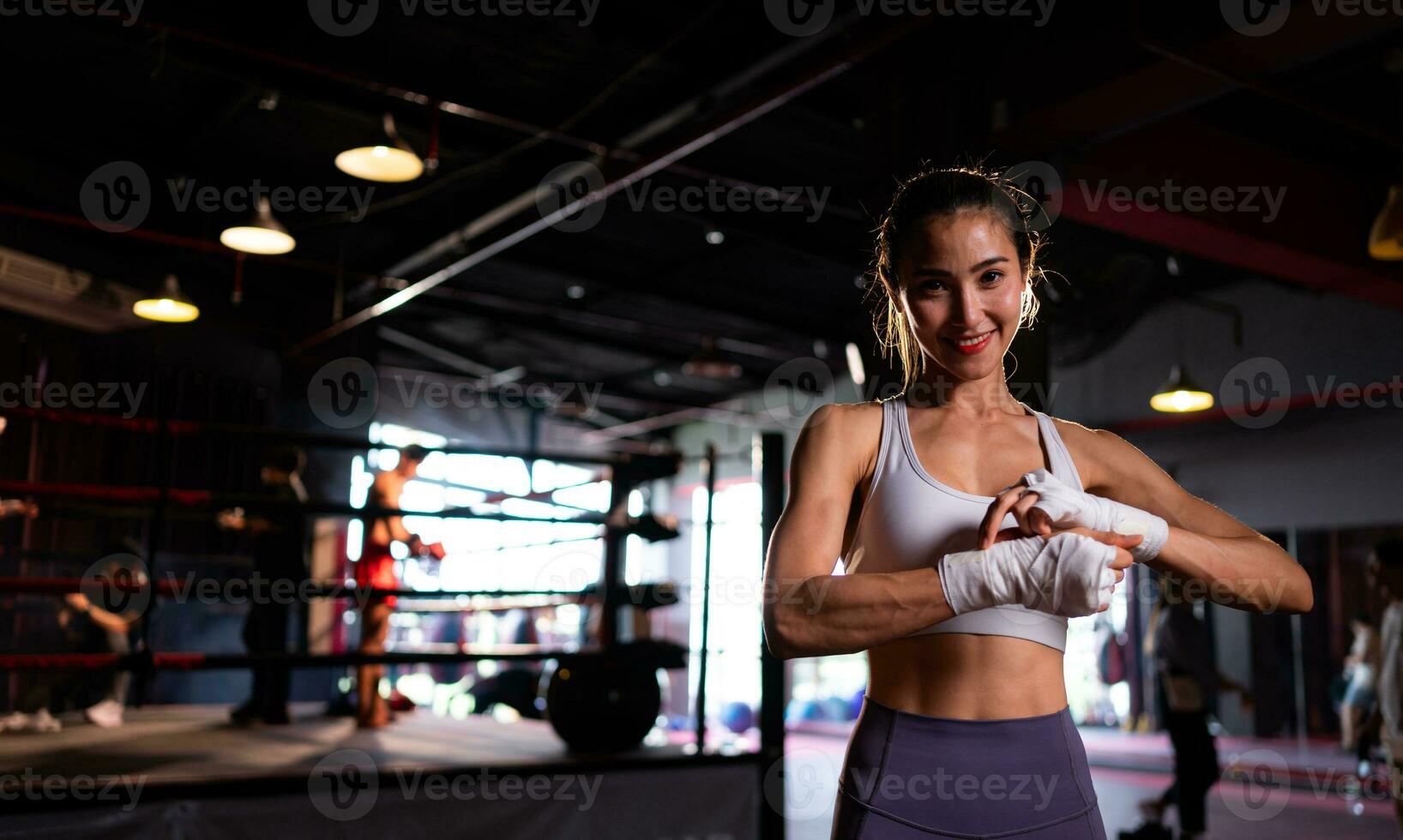 retrato de mujer aprendizaje muay tailandés a construir arriba el fuerza de el cuerpo y utilizar eso para autodefensa. son utilizando mano envuelve antes de poniendo en boxeo guantes para boxeo foto