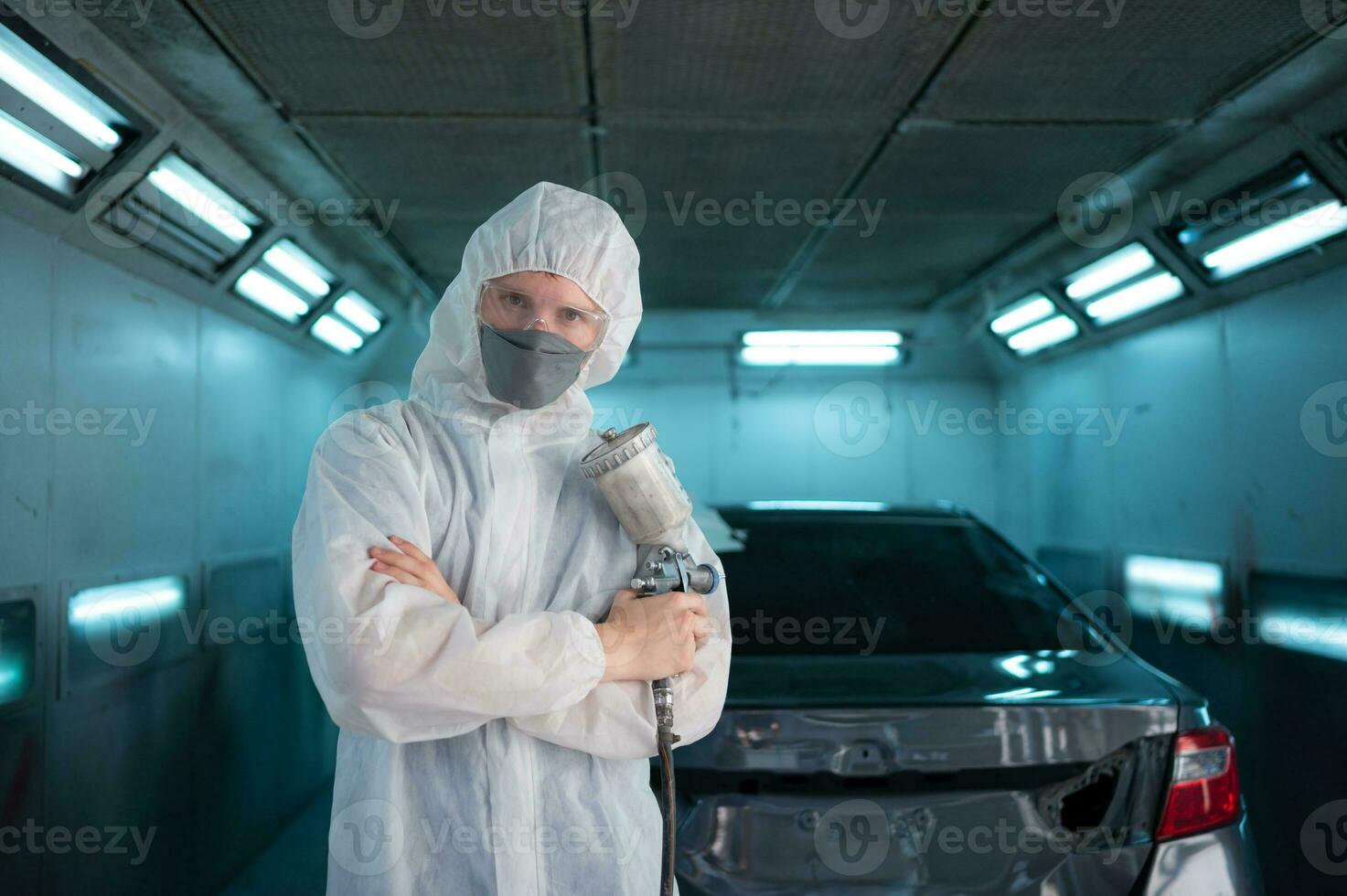 Auto mechanic in car spray room Use a spray nozzle Injected to the side of the car body with care to create beauty that blends with the original color of the car. photo