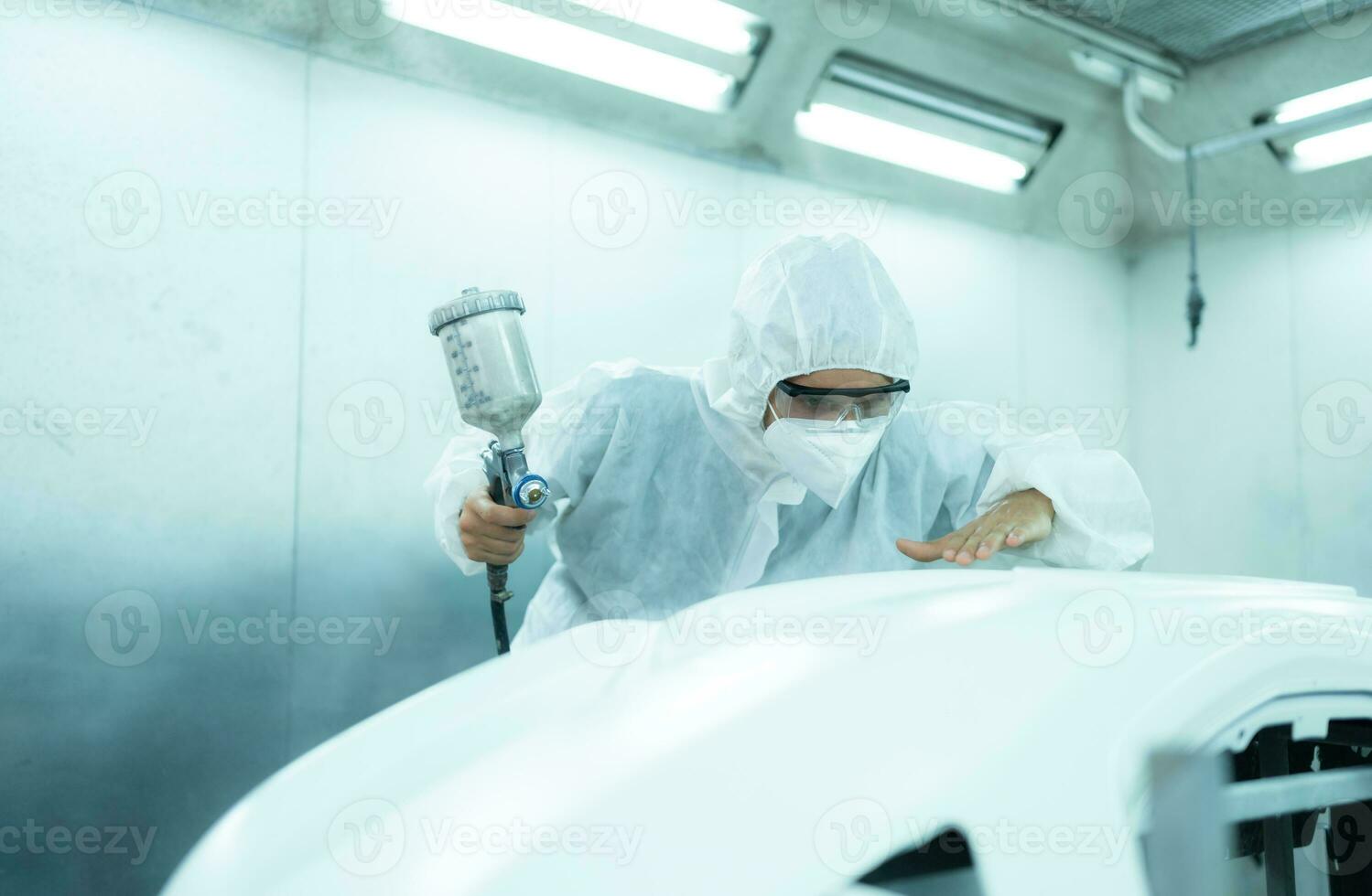 Auto mechanic in car spray room Inspecting the paint sprayed into the front bumper of the car that the pigment is complete, beautiful, harmonious with the original color of the car photo