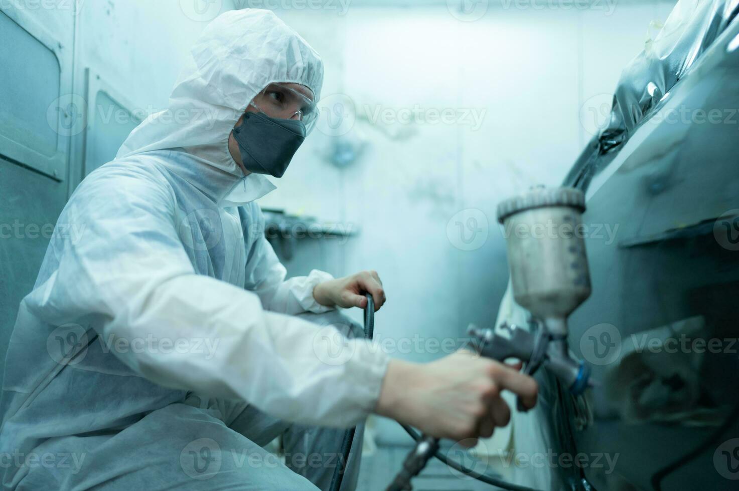 Auto mechanic in car spray room Use a spray nozzle Injected to the side of the car body with care to create beauty that blends with the original color of the car. photo