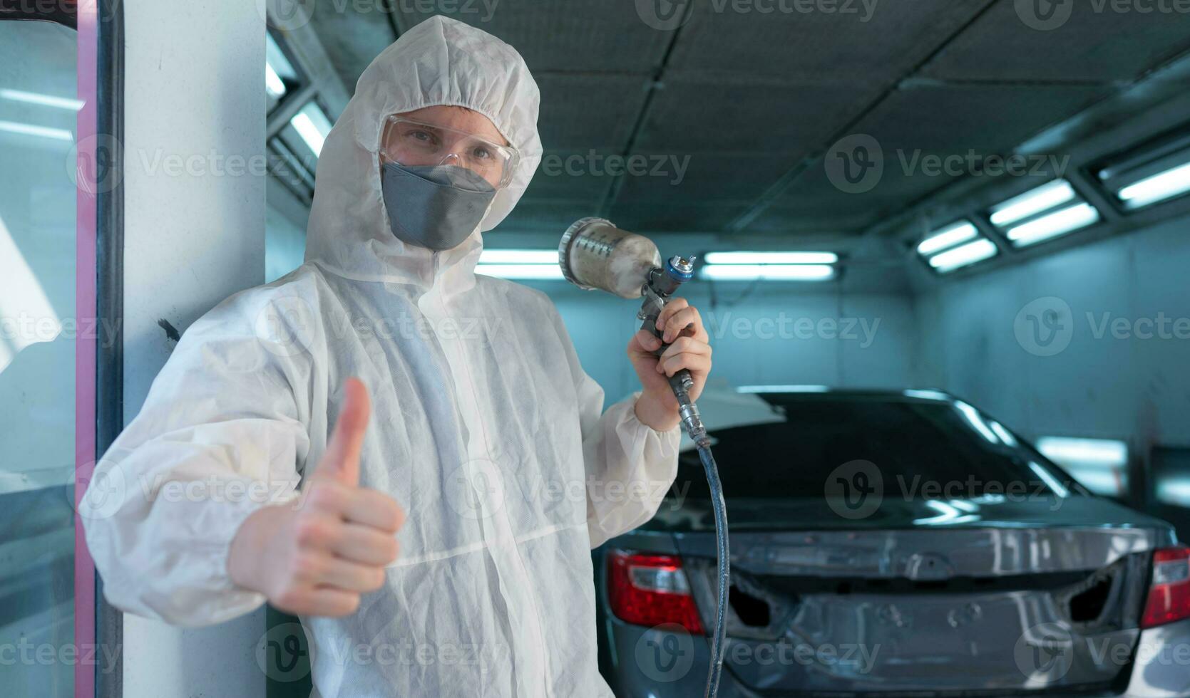 Auto mechanic in car spray room Use a spray nozzle Injected to the side of the car body with care to create beauty that blends with the original color of the car. photo